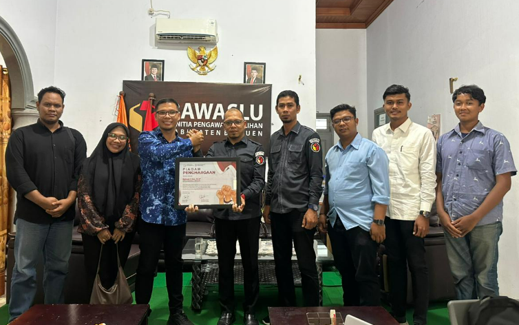 Perwakilan Panitia Bersama Eco-Flag Merah Putih menyerahkan penghargaan kepada Ketua Bawaslu Kabupaten Bireuen, Selasa 18 November 2025.
